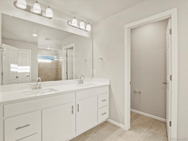 bathroom with a shower with shower door, tile patterned floors, and vanity