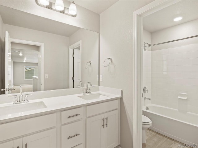 full bathroom featuring bathtub / shower combination, wood-type flooring, toilet, and vanity