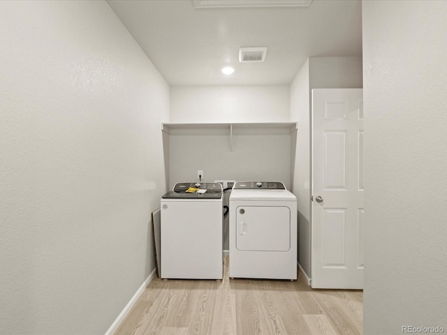 laundry room with light wood-type flooring and washer and dryer