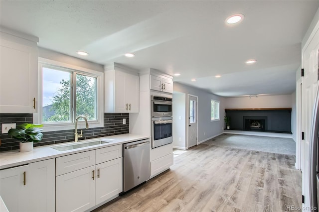 8897 Wagner Ln, Westminster, CO 80031 - kitchen featuring appliances with stainless steel finishes, white cabinets, light countertops, and recessed lighting