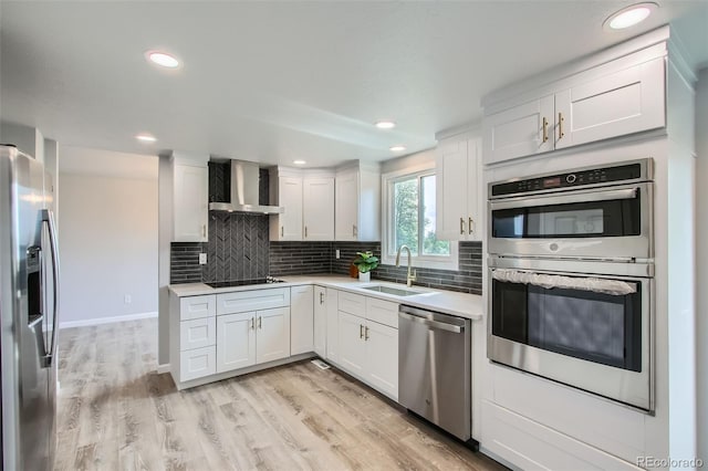 8897 Wagner Ln, Westminster, CO 80031 - kitchen featuring wall chimney range hood, stainless steel appliances, tasteful backsplash, light countertops, and white cabinetry