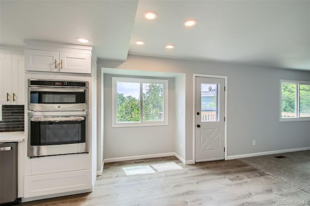 8897 Wagner Ln, Westminster, CO 80031 - kitchen with appliances with stainless steel finishes, white cabinets, recessed lighting, light wood-style floors, and light countertops