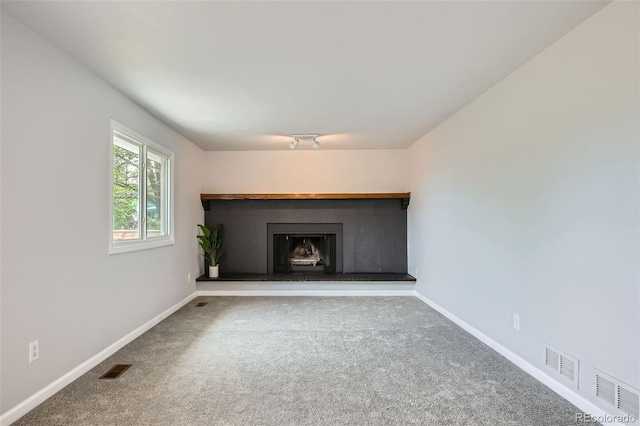 8897 Wagner Ln, Westminster, CO 80031 - unfurnished living room featuring carpet flooring and a fireplace with raised hearth