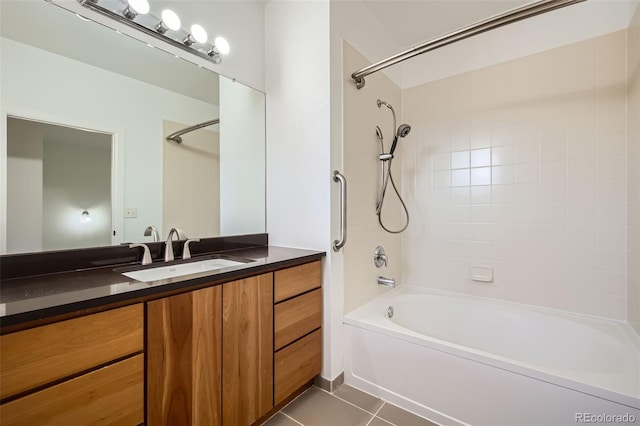 bathroom featuring tile patterned flooring, vanity, and tiled shower / bath