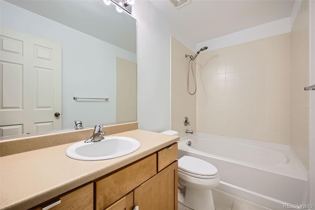 full bathroom featuring tile patterned flooring, tiled shower / bath, vanity, and toilet