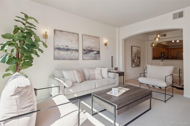 living room featuring arched walkways and carpet flooring