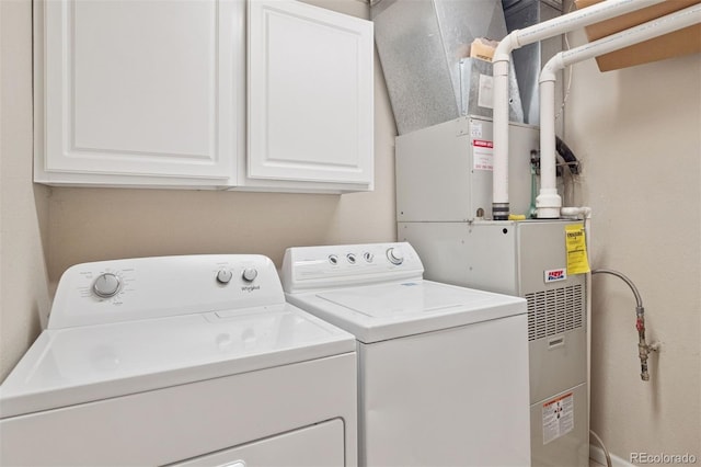 clothes washing area featuring washer and clothes dryer and cabinet space