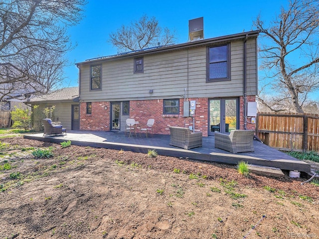 back of house featuring brick siding, fence, and an outdoor hangout area