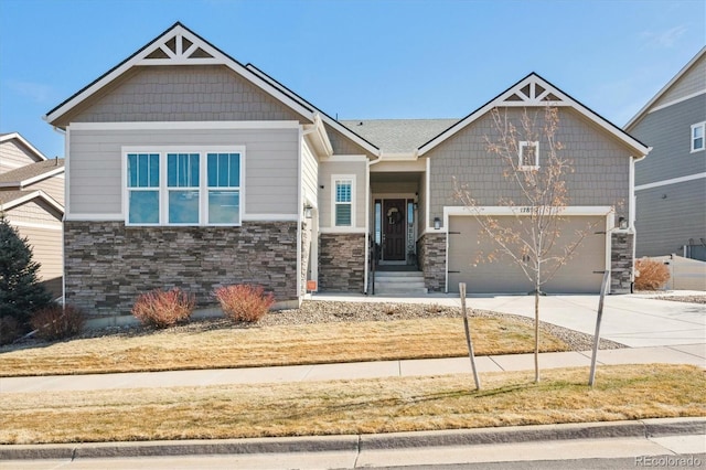 craftsman-style house featuring stone siding, driveway, and an attached garage