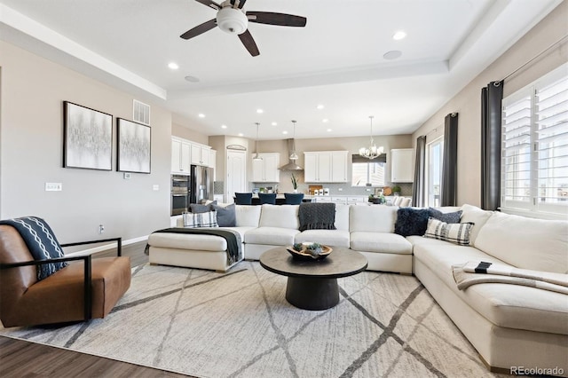 living room with light wood-style flooring, visible vents, a wealth of natural light, and recessed lighting