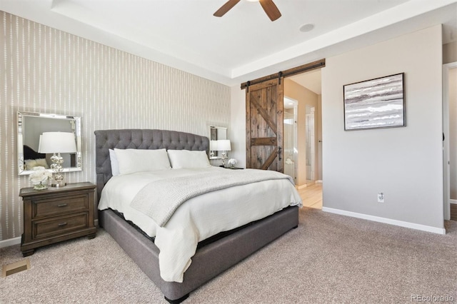 carpeted bedroom featuring baseboards, a barn door, visible vents, and wallpapered walls