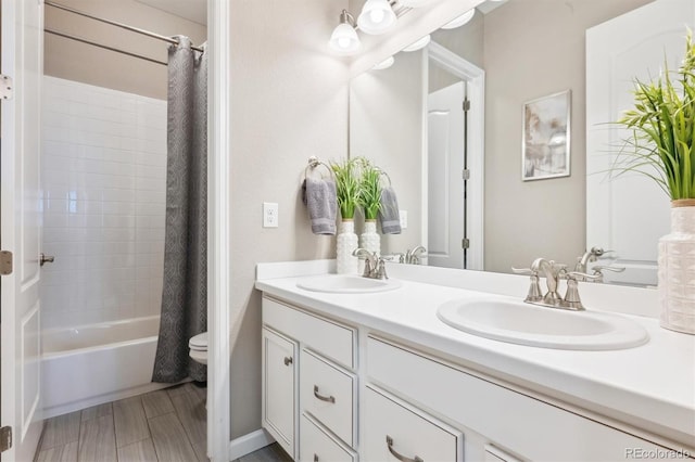 full bathroom with double vanity, shower / bath combo, a sink, and toilet