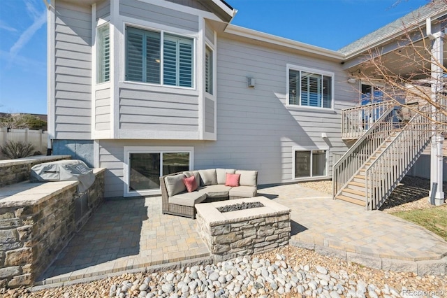 rear view of property with an outdoor fire pit, stairway, and a patio area