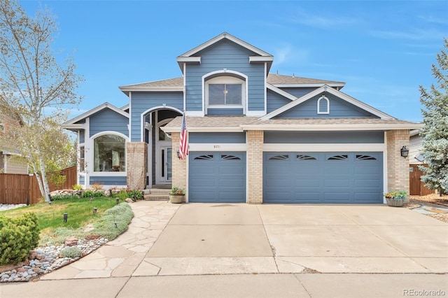 9371 Desert Willow Trl, Highlands Ranch, CO 80129 - view of front of property featuring driveway, brick siding, fence, a shingled roof, and a garage