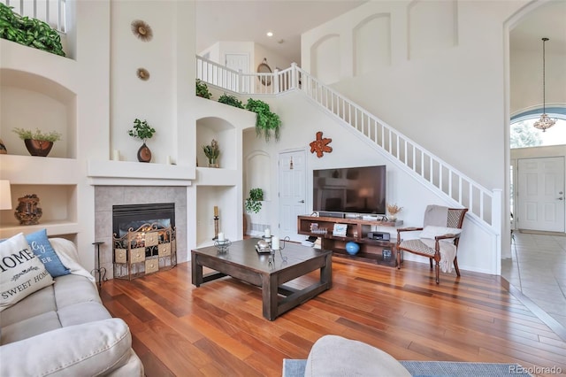 9371 Desert Willow Trl, Highlands Ranch, CO 80129 - living room featuring a high ceiling, hardwood / wood-style flooring, built in shelves, and stairway