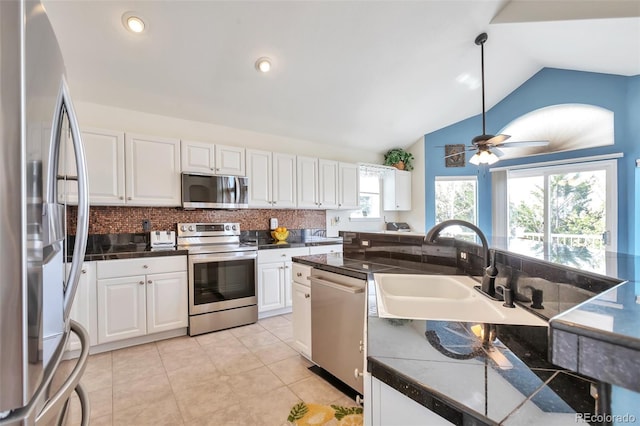 9371 Desert Willow Trl, Highlands Ranch, CO 80129 - kitchen with appliances with stainless steel finishes, vaulted ceiling, white cabinetry, tasteful backsplash, and ceiling fan