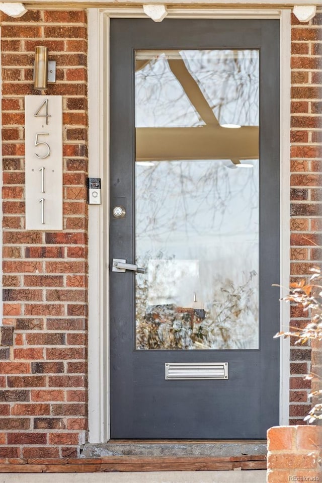 entrance to property featuring brick siding