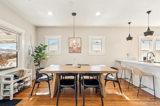 dining space with light wood-style floors and recessed lighting