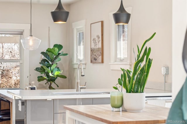 interior space with hanging light fixtures, butcher block counters, and a sink