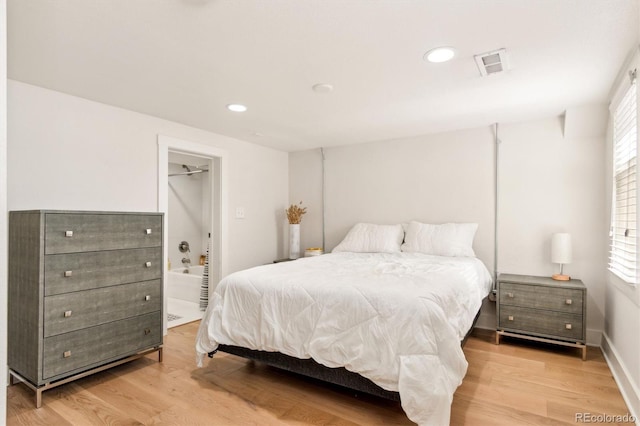 bedroom featuring light wood-style flooring, visible vents, ensuite bathroom, and recessed lighting