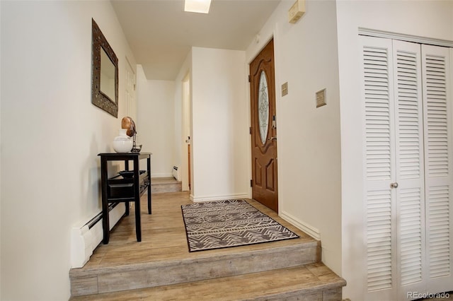 interior space with a baseboard heating unit and wood finished floors