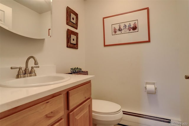 half bathroom with toilet, vanity, and baseboard heating