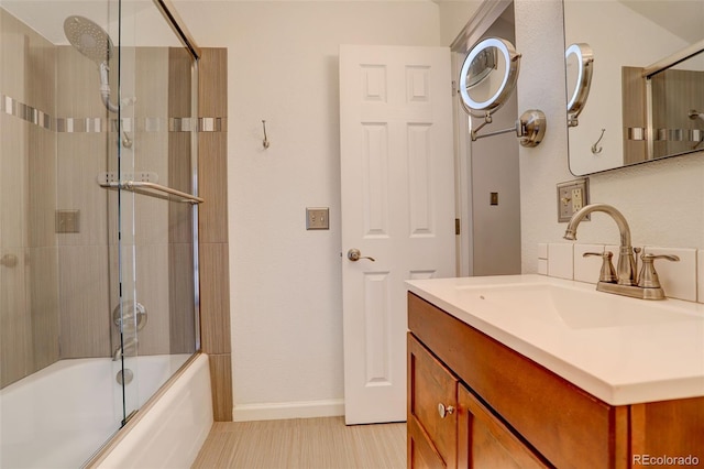 bathroom featuring enclosed tub / shower combo, vanity, and baseboards