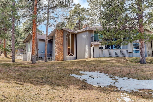 exterior space featuring a front lawn and a chimney