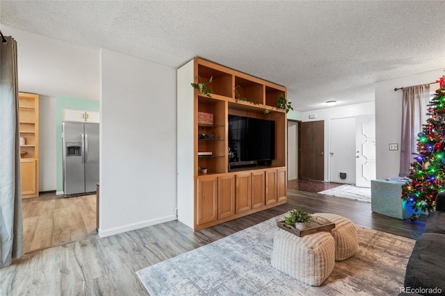 living room with a textured ceiling and light wood-type flooring