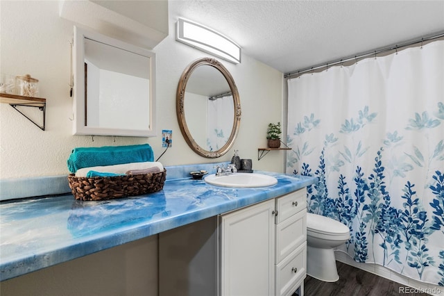 bathroom featuring hardwood / wood-style floors, vanity, a textured ceiling, and toilet