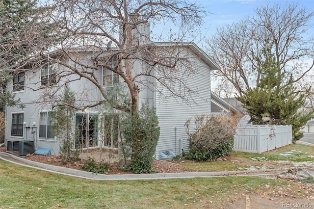 view of property exterior with a yard and central AC