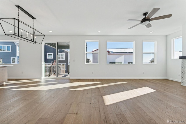 unfurnished living room with ceiling fan and light wood-type flooring