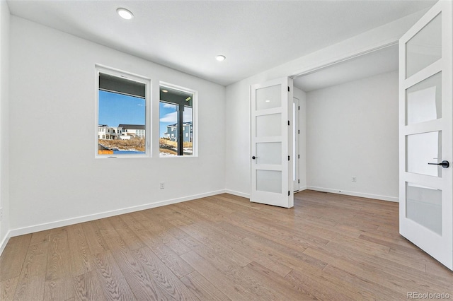 unfurnished bedroom featuring french doors and light hardwood / wood-style flooring