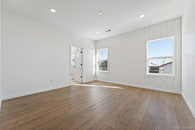 spare room with wood walls and wood-type flooring