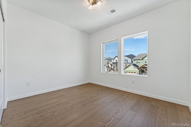 spare room featuring wood-type flooring