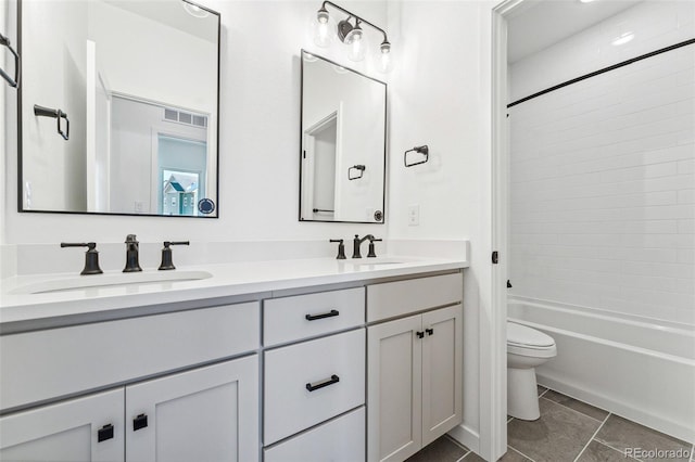 full bathroom featuring tile patterned flooring, vanity, toilet, and tiled shower / bath combo