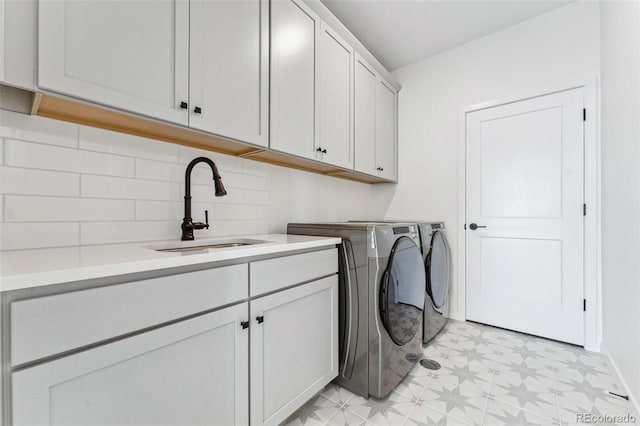 laundry area featuring sink, cabinets, and independent washer and dryer