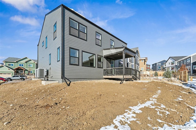 snow covered rear of property with central air condition unit