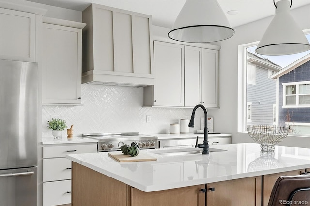 kitchen with appliances with stainless steel finishes, light countertops, and a sink