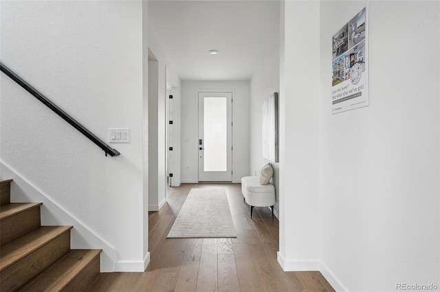 entrance foyer with hardwood / wood-style flooring, stairway, and baseboards