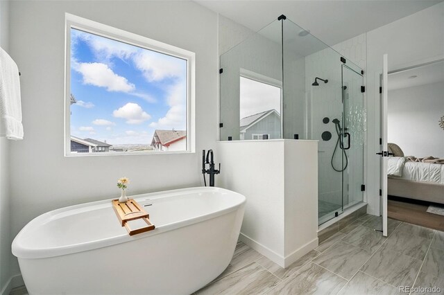 bathroom with connected bathroom, a shower stall, and a freestanding tub