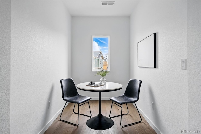 dining area featuring visible vents, baseboards, and wood finished floors