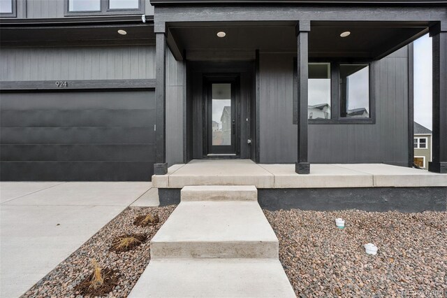 doorway to property with an attached garage and driveway