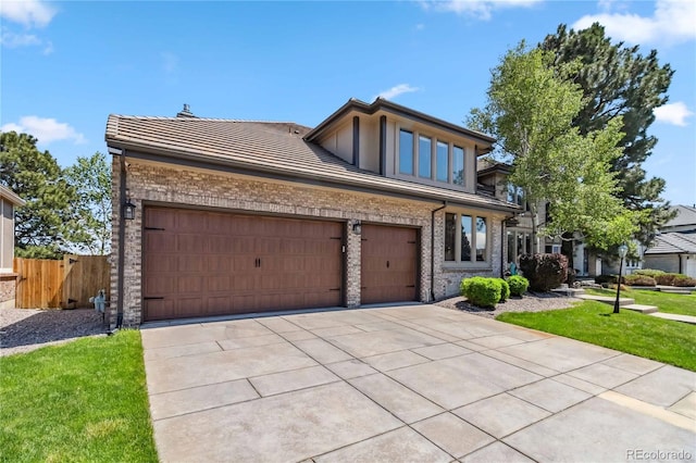 2154 S Parfet Dr, Lakewood, CO 80227 - view of front of home with a tiled roof, driveway, a garage, and brick siding