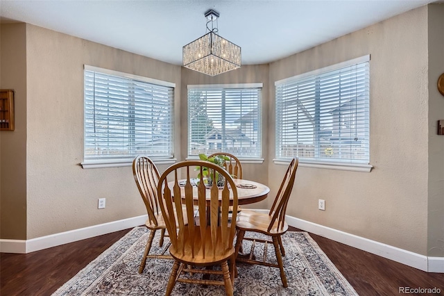 dining area with baseboards, a notable chandelier, and wood finished floors