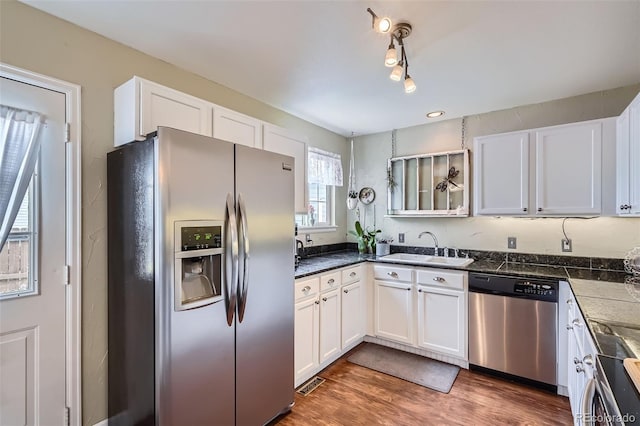 kitchen with visible vents, white cabinets, appliances with stainless steel finishes, and a sink