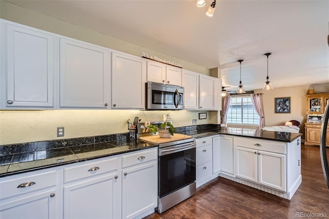 kitchen featuring stainless steel microwave, dark wood-type flooring, a peninsula, electric stove, and white cabinetry