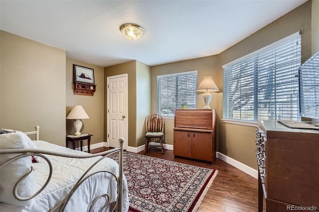 bedroom with baseboards and wood finished floors