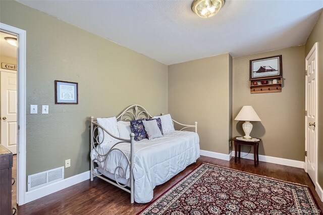 bedroom featuring wood finished floors, visible vents, and baseboards