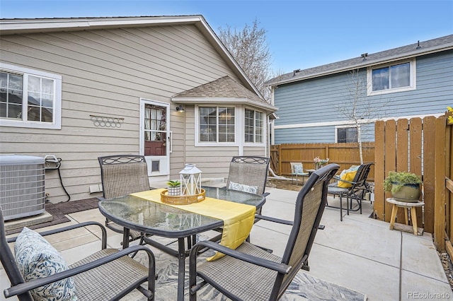 view of patio / terrace with outdoor dining area, central AC, and fence